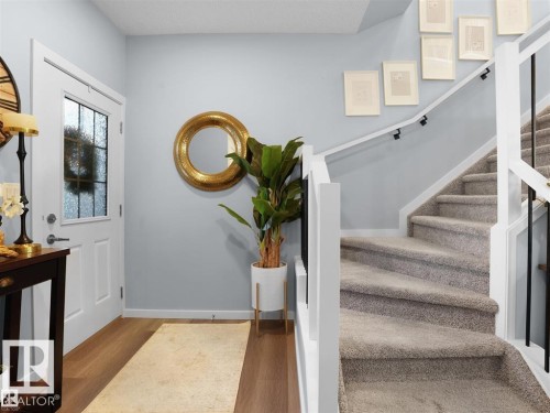 Entryway featuring wood-finish flooring, a white door with frosted glass insert, and light blue wall color - 207 41 Avenue, Edmonton, AB 