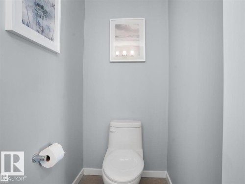 Modern toilet with a low-profile tank, complemented by light grey walls and white baseboards - 207 41 Avenue, Edmonton, AB 