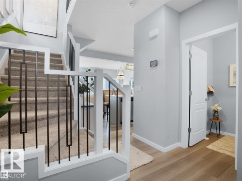 Carpeted staircase with contemporary metal balusters and white newel posts - 207 41 Avenue, Edmonton, AB 