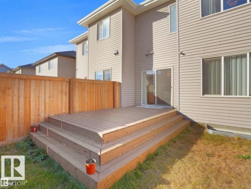 Spacious rear deck with multi-level steps, wood plank fencing, and direct access to the interior via sliding glass doors - 207 41 Avenue, Edmonton, AB 