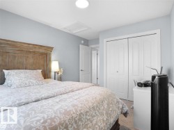 Spacious bedroom featuring light blue walls, carpet flooring, a white bi-fold closet, and a white interior door - 
