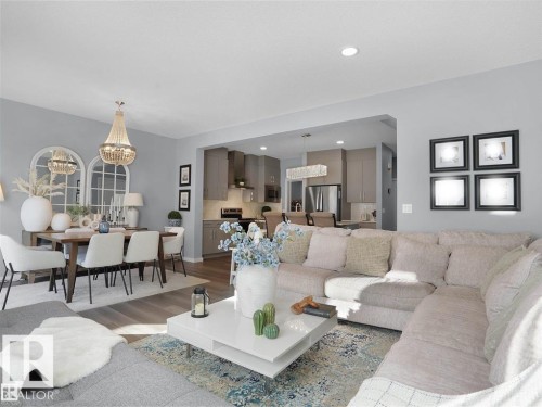 Open-concept living space featuring wood-finish flooring, recessed lighting, and a modern kitchen with stainless steel appliances - 207 41 Avenue, Edmonton, AB 