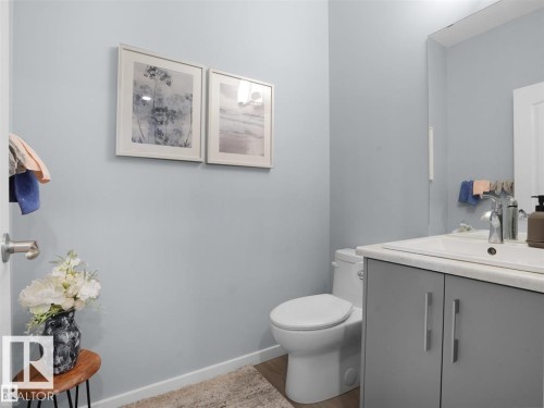 Modern bathroom featuring light blue walls and wood-finish flooring - 207 41 Avenue, Edmonton, AB 