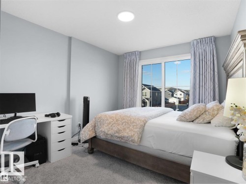 Carpeted interior room featuring a large sliding glass door, a built-in recessed ceiling light, and light-toned walls - 207 41 Avenue, Edmonton, AB 