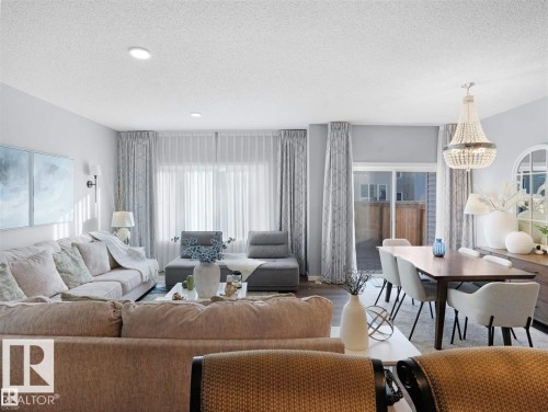 Open-concept living and dining areas featuring wood-finish flooring, recessed lighting, and a sliding glass patio door - 207 41 Avenue, Edmonton, AB 