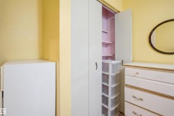 Built-in closet with bifold doors, integrated shelving, and brass hardware - 