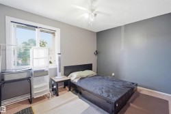 Room featuring a window with white trim, a ceiling fan with light fixture, and a two-tone wall treatment - 