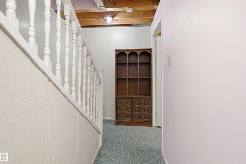 White spindle railing with a light-toned wood-look paneling wall - 17 Lakewood Village, Edmonton, AB 