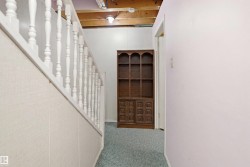 White spindle railing with a light-toned wood-look paneling wall - 