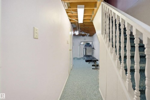 Staircase with white balusters and carpeted treads - 17 Lakewood Village, Edmonton, AB 