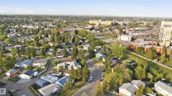 Established residential neighborhood with mature trees, paved streets, and a mix of single-family homes and multi-unit buildings - 
