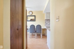 Wood-finish bi-fold doors open to a brightly lit interior with light yellow walls and wood-finish flooring - 