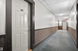 Hallway with patterned carpeting, textured wainscoting, and white upper walls - 