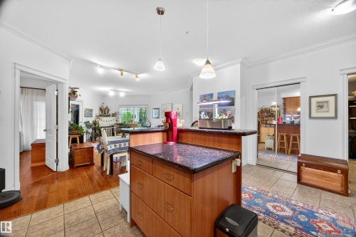 Kitchen island with a dark granite-style countertop and wood-finish cabinetry - 304 10116 80 Avenue, Edmonton, AB 