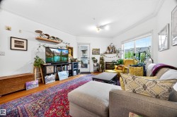 Living area featuring wood-finish flooring, white crown molding, recessed lighting, and a large window providing ample natural light - 