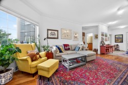 Bright living area featuring large windows, wood-finish flooring, white crown molding, recessed lighting, and a neutral wall palette - 