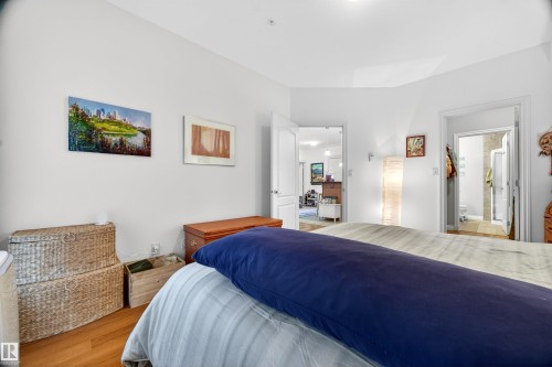 Bedroom featuring wood-finish flooring, white walls, and a recessed ceiling light - 304 10116 80 Avenue, Edmonton, AB 