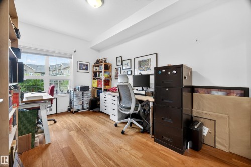Room featuring wood-finish flooring, a broad window, and a light-toned ceiling - 304 10116 80 Avenue, Edmonton, AB 