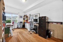 Room featuring wood-finish flooring, a broad window, and a light-toned ceiling - 