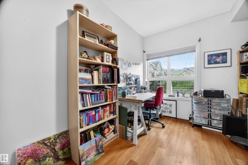 Room featuring wood-finish flooring, a large window, white trim, and light-colored walls - 304 10116 80 Avenue, Edmonton, AB 