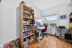 Room featuring wood-finish flooring, a large window, white trim, and light-colored walls - 