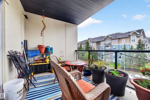 Private balcony featuring a dark ceiling, light-toned walls, and a glass-paneled railing - 304 10116 80 Avenue, Edmonton, AB 