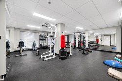 Fitness room featuring rubberized flooring, mirrored walls, drop ceiling, and recessed lighting - 