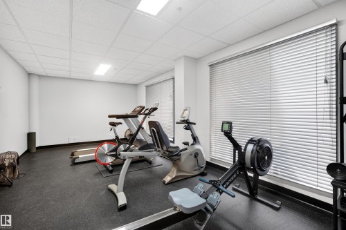 Dedicated fitness space featuring rubber flooring, recessed lighting, and white walls - 304 10116 80 Avenue, Edmonton, AB 