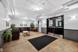 Spacious common area featuring durable tile flooring, wainscoting, and recessed lighting - 