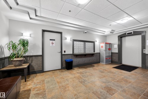 Building common area featuring large format tile flooring and a drop ceiling with integrated lighting - 304 10116 80 Avenue, Edmonton, AB 