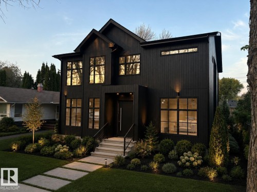 Modern black vertical siding exterior with prominent multi-pane windows - 9243 148 Street, Edmonton, AB 