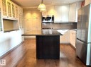 Central kitchen island with dark cabinetry and a polished countertop - 15003 81 Street, Edmonton, AB 