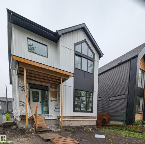 Modern architectural design featuring vertical white siding and black paneling accents - 14706 103 Avenue Nw, Edmonton, AB 