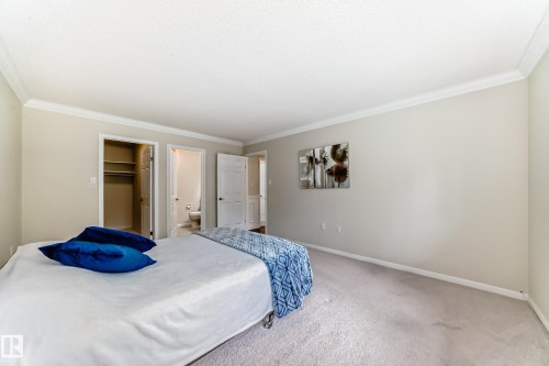Carpeted bedroom with neutral wall tones and crown molding - 50 303 Twin Brooks Drive Nw, Edmonton, AB 