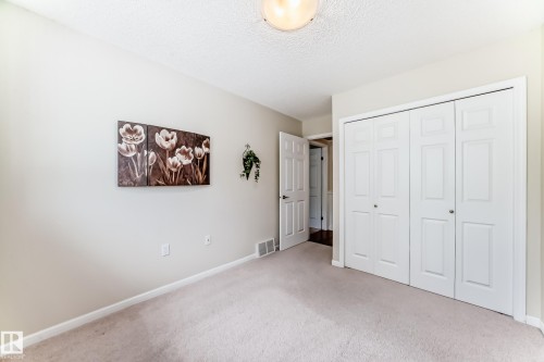 Neutral toned walls with textured ceiling and light-colored carpeting - 50 303 Twin Brooks Drive Nw, Edmonton, AB 
