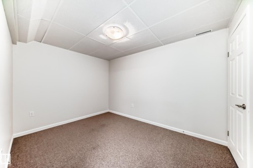 Interior room featuring neutral white walls and brown carpeting - 50 303 Twin Brooks Drive Nw, Edmonton, AB 
