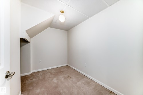 Neutral tone wall finishes, sloped ceiling details, and a recessed clothing storage area - 50 303 Twin Brooks Drive Nw, Edmonton, AB 