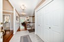 Entryway featuring light-toned flooring, white bi-fold closet doors, and contrasting wood-finish flooring - 50 303 Twin Brooks Drive Nw, Edmonton, AB 