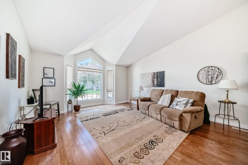 Living area featuring vaulted ceilings, bay window, and wood-finish flooring - 50 303 Twin Brooks Drive Nw, Edmonton, AB 