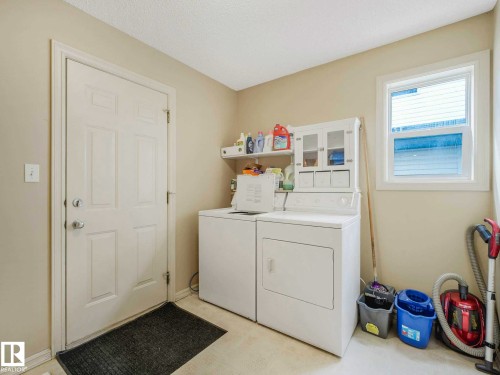 Laundry room featuring a white paneled door, a single window with white trim, and light beige wall paint - 1116 Lincoln Crescent, Edmonton, AB - Indoor Photo Showing Laundry Room
