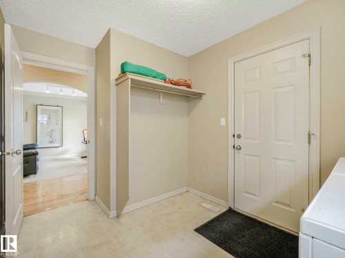 Entryway featuring a built-in coat rack with shelf, a white paneled door, and neutral tone flooring - 1116 Lincoln Crescent, Edmonton, AB - Indoor Photo Showing Other Room