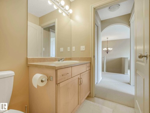 Bathroom vanity featuring an integrated sink, light-toned countertop, and wood-finish cabinetry - 1116 Lincoln Crescent, Edmonton, AB - Indoor Photo Showing Bathroom