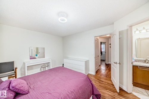 Bedroom featuring wood-finish flooring, white walls, and a ceiling-mounted light fixture - 8 Campbell Court, Leduc, AB 