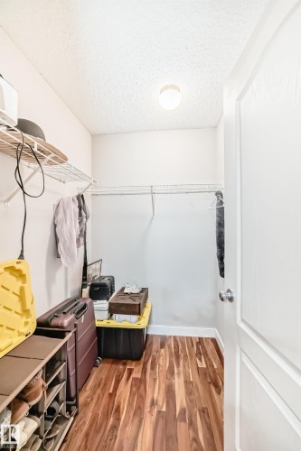 Walk-in closet with wood-finish flooring, wire shelving, and a flush-mount ceiling light - 8 Campbell Court, Leduc, AB 