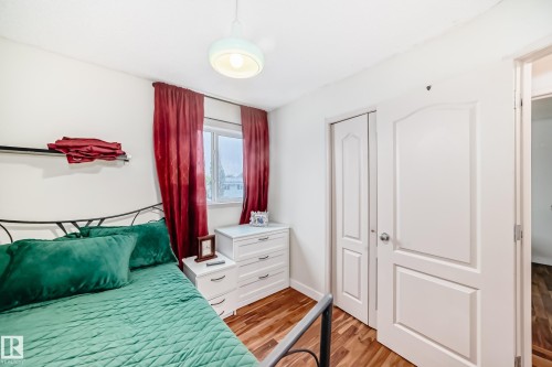Bright room featuring wood-finish flooring, a double-panel door, and bi-fold closet doors - 8 Campbell Court, Leduc, AB 