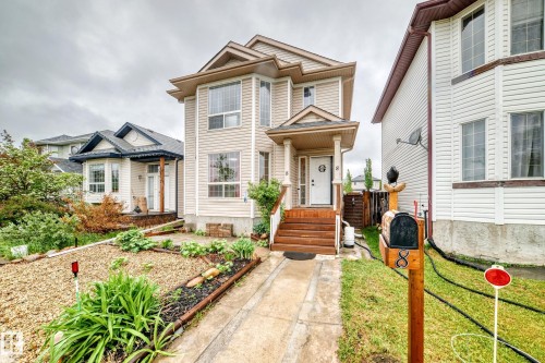 Two-story residence featuring light-colored siding and a covered front porch with stained wood steps - 8 Campbell Court, Leduc, AB 