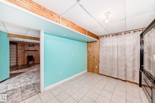Room featuring light-colored square tile flooring and a drop panel ceiling - 8 Campbell Court, Leduc, AB 