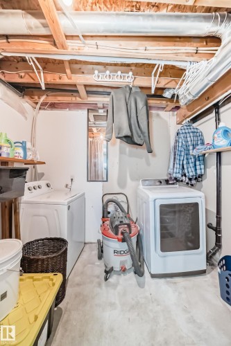 Dedicated laundry area featuring a white top-load washing machine and a white front-load dryer - 8 Campbell Court, Leduc, AB 