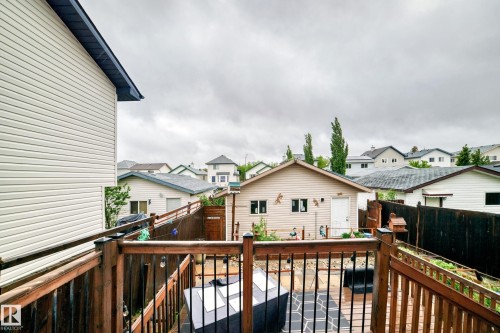 Upper-level wood deck featuring dark stained railings and black metal spindles - 8 Campbell Court, Leduc, AB 