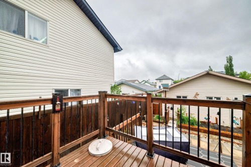 Upper-level wood-finish deck with dark metal railings - 8 Campbell Court, Leduc, AB 